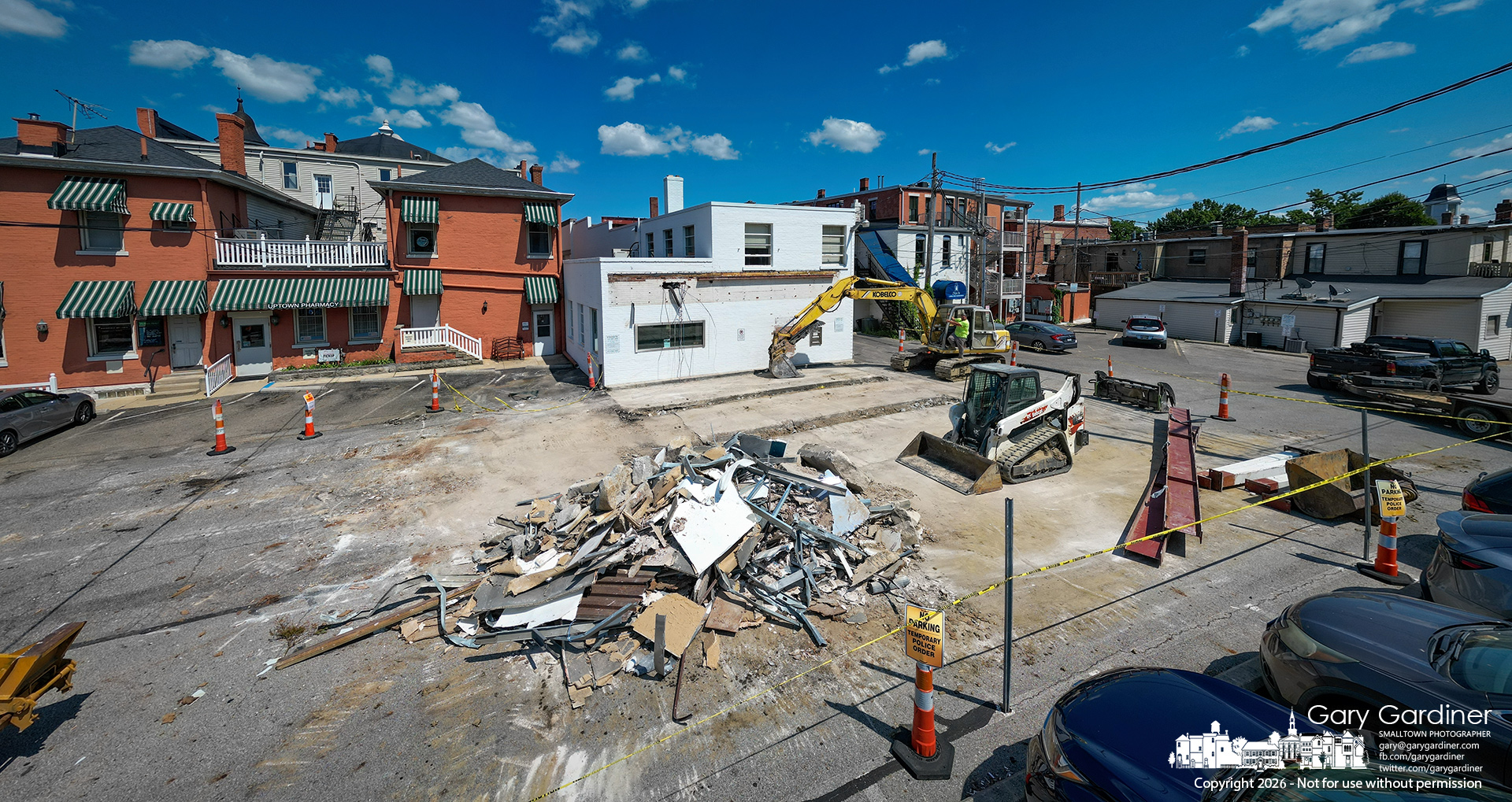 A demolition crew removed the drive-thru canopy at the rear of the Old Middlefield Bank in Uptown on Monday, marking the first step in a project beginning next summer to revitalize the parking and roadway between West Main and West College. (My Final Photo for August 3, 2026. Photo by Gary Gardiner)