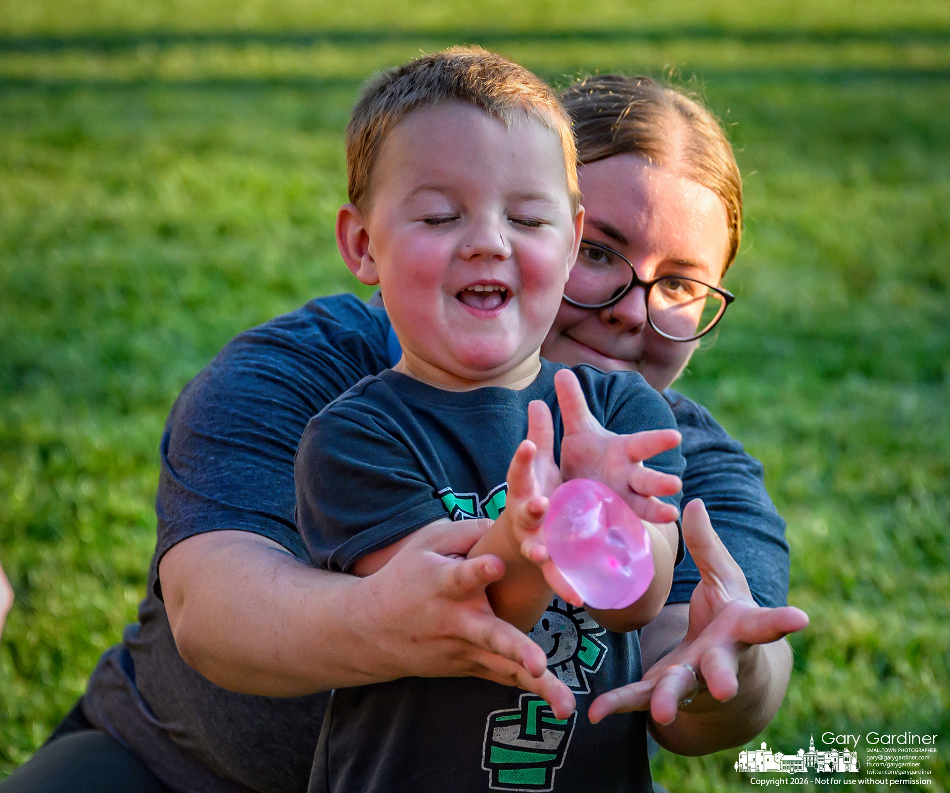 Mother and child work together to win the water balloon toss at National Night Out, but fail on their first attempt. (My Final Photo for August 4, 2026. Photo by Gary Gardiner)
