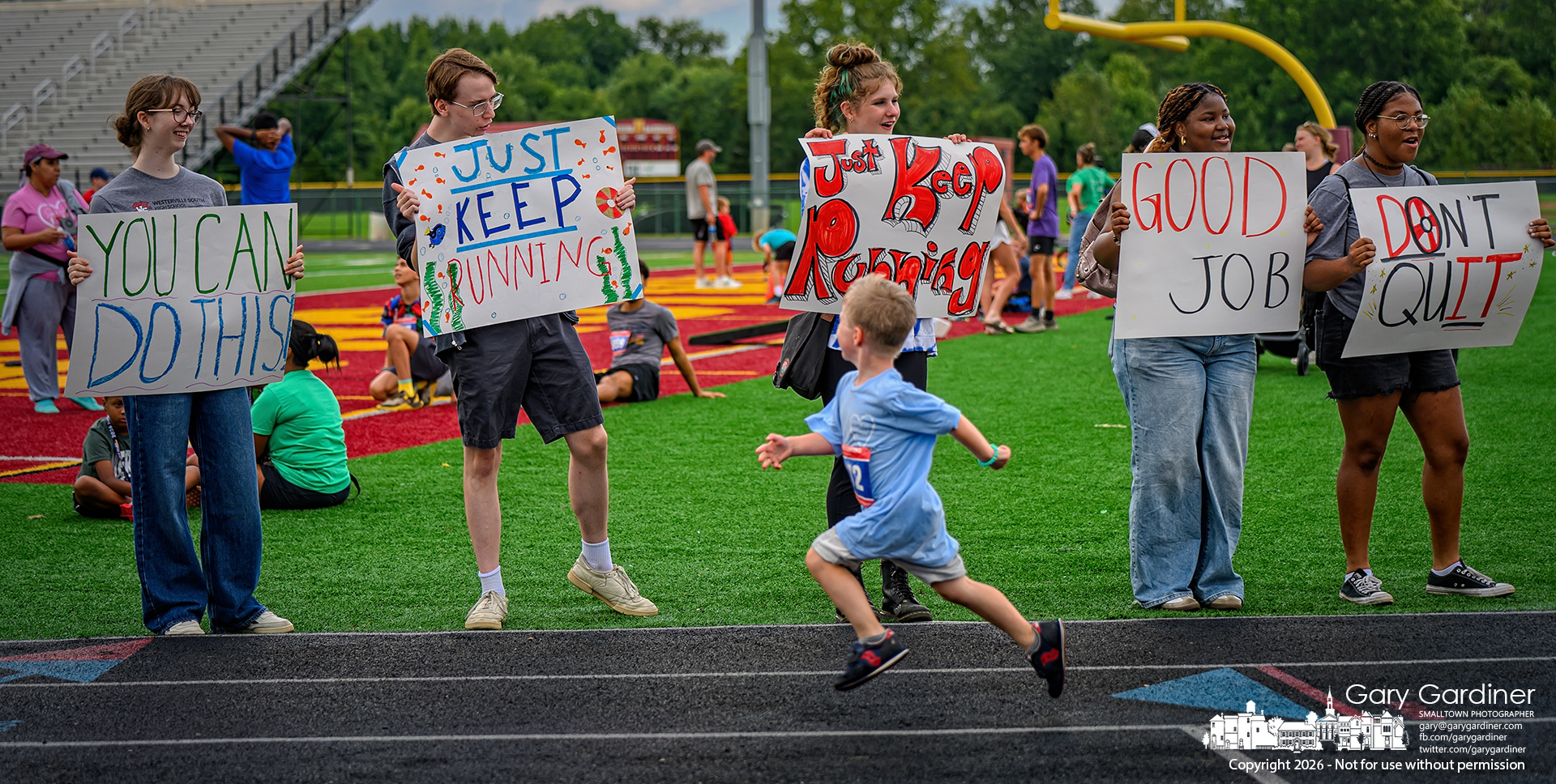 A young runner admires signs, chants, and cheers as he nears the finish line of a 5K run at Night of Hope at Westerville North High School (My Final Photo for August 22, 2026. Photo by Gary Gardiner)