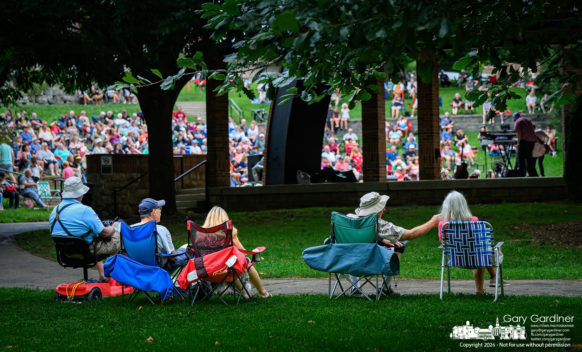 Some of the music fans listening to Long Play, a local 70s & 80s group, sit behind the stage during Sunday's concert at the Alum Creek Park amphitheater. (My Final Photo for August 2, 2026. Photo by Gary Gardiner)
