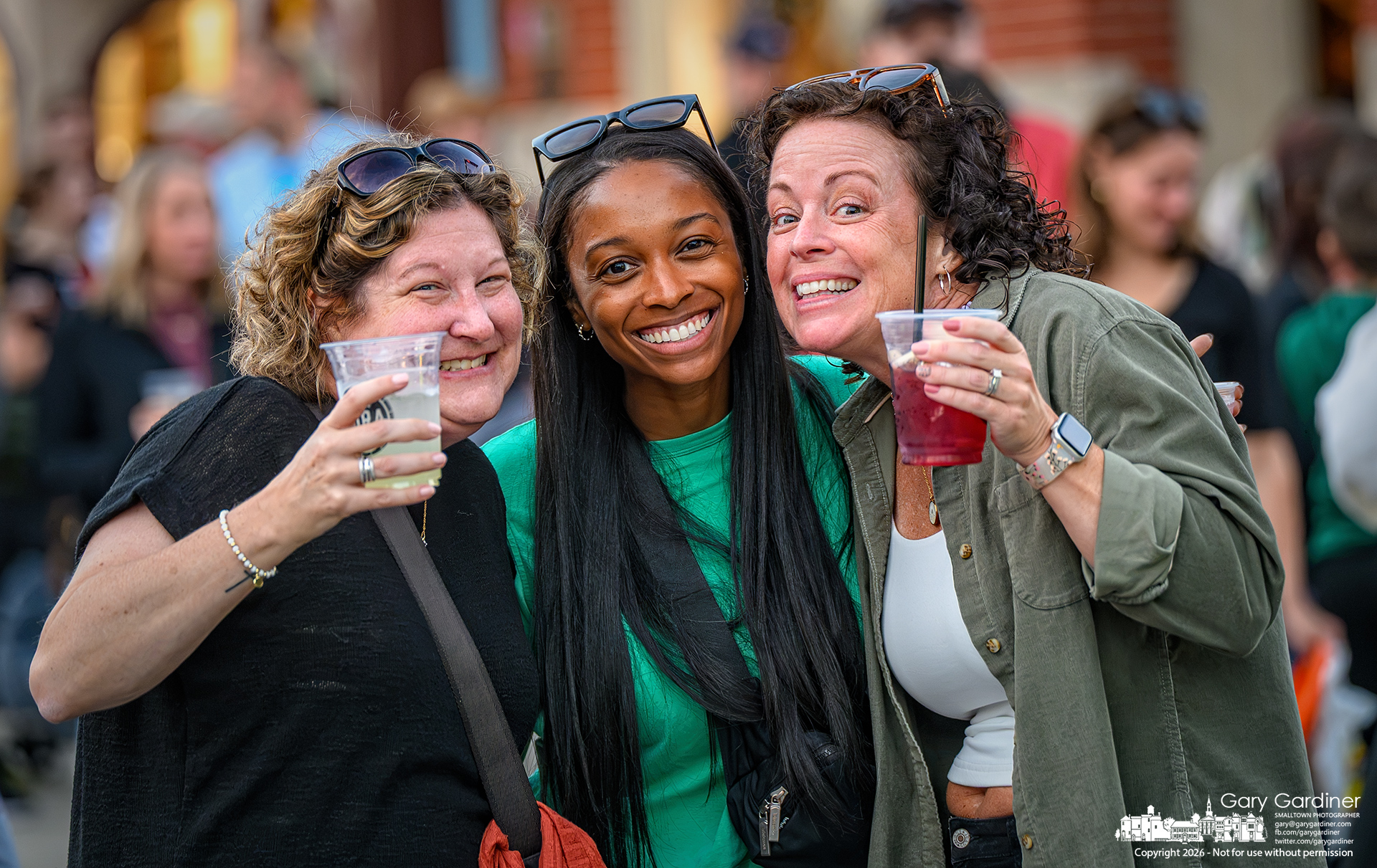 Good friends, big smiles, and liquid refreshment mark Fourth Friday in Uptown for this trio. (My Final Photo for September 25, 2026. Photo by Gary Gardiner)