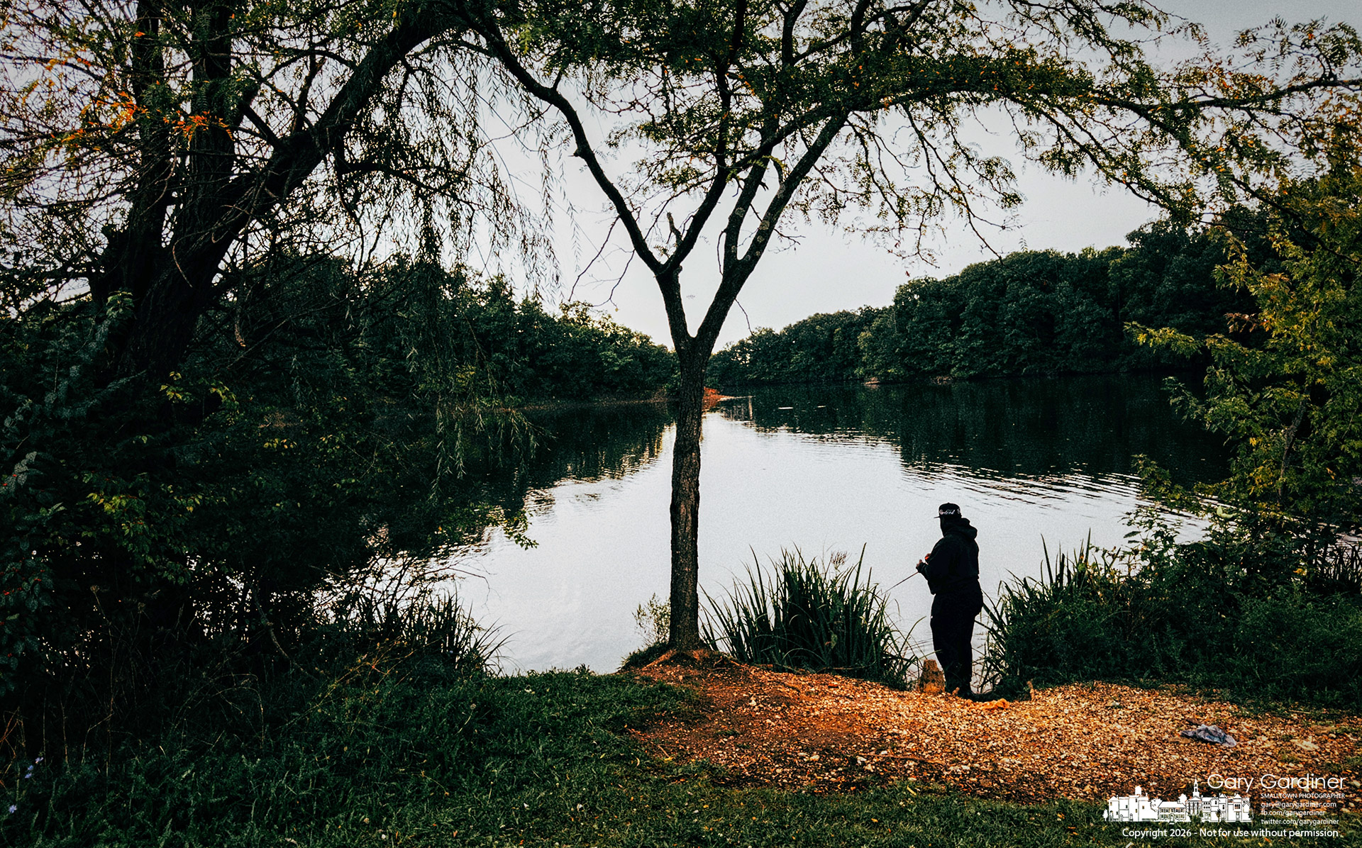 An angler fishing under dark clouds in the late afternoon at Three Bridges Park on Hoover Reservoir gets in a few final tosses before heavy rain interrupted fishing and boating on the lake. (My Final Photo for September 14, 2026. Photo by Gary Gardiner)