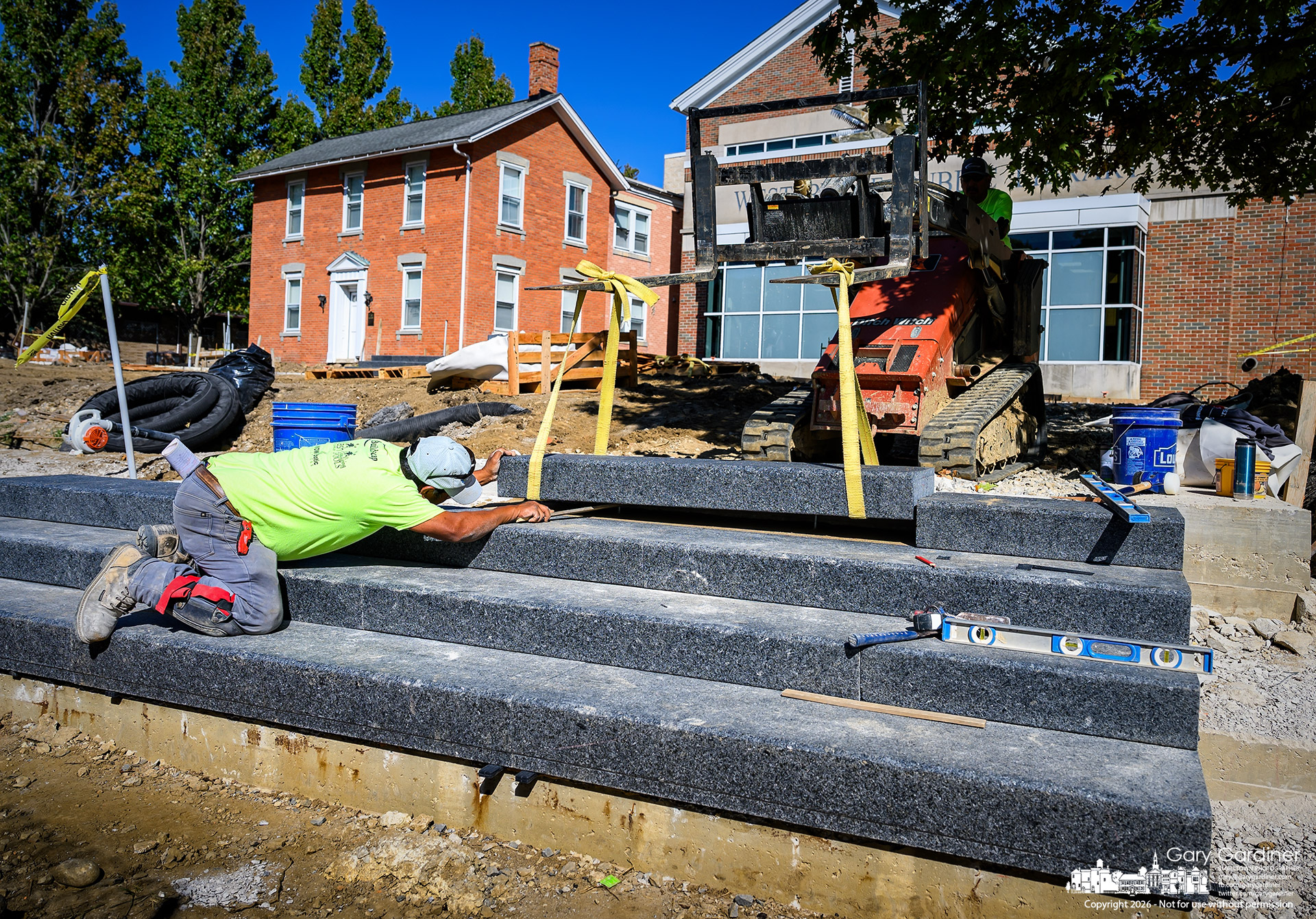 A section of marble steps is lowered into place Friday in front of the Westerville library, which is nearing completion of the renovated entrance. (My Final Photo for October 9, 2026. Photo by Gary Gardiner)
