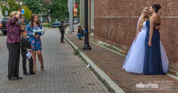 East Main Street in Uptown Westerville became a photo studio for several minutes as a bridal party in the foreground and a student in the background use the busy street as the location for their photo sessions. My Final Photo for Oct. 12, 2017. East Main Street in Uptown Westerville became a photo studio for several minutes as a bridal party in the foreground and a student in the background use the busy street as the location for their photo sessions. My Final Photo for Oct. 12, 2017.