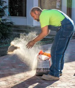 A bricklayer tosses sand into the new paver bricks installed at the courtyard in front of city hall. My Final Photo for Oct. 7, 2017 A bricklayer tosses sand into the new paver bricks installed at the courtyard in front of city hall. My Final Photo for Oct. 7, 2017