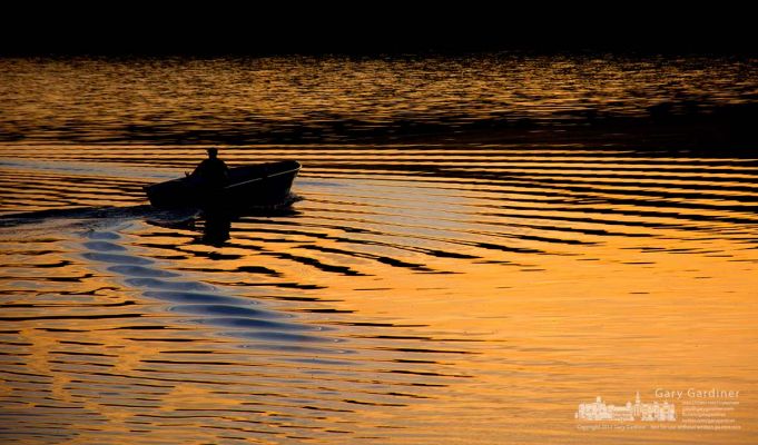 A fisherman’s boat creates a second set of wakes as he joins another angler traveling across Hoover Reservoir at sunrise. My Final Photo for Oct. 21, 2013. A fisherman’s boat creates a second set of wakes as he joins another angler traveling across Hoover Reservoir at sunrise. My Final Photo for Oct. 21, 2013.