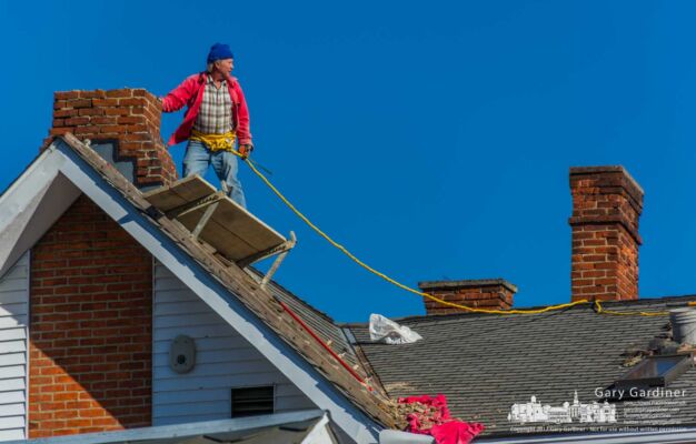 A brickmason surveys his position and movement on the roof of an East College house as he makes repairs to its chimneys. My Final Photo for Nov. 28, 2017. A brickmason surveys his position and movement on the roof of an East College house as he makes repairs to its chimneys. My Final Photo for Nov. 28, 2017.