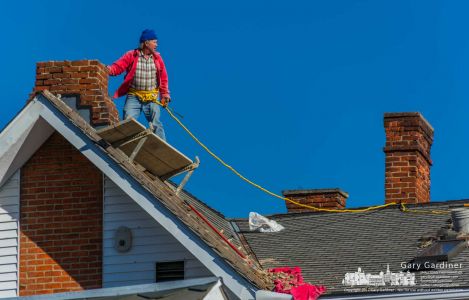 A brickmason surveys his position and movement on the roof of an East College house as he makes repairs to its chimneys. My Final Photo for Nov. 28, 2017. A brickmason surveys his position and movement on the roof of an East College house as he makes repairs to its chimneys. My Final Photo for Nov. 28, 2017.