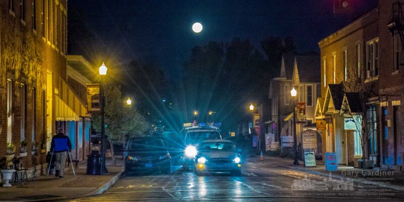 A full moon rises behind traffic on East College on a Friday night in Uptown Westerville. My Final Photo for Nov. 3, 2017. A full moon rises behind traffic on East College on a Friday night in Uptown Westerville. My Final Photo for Nov. 3, 2017.