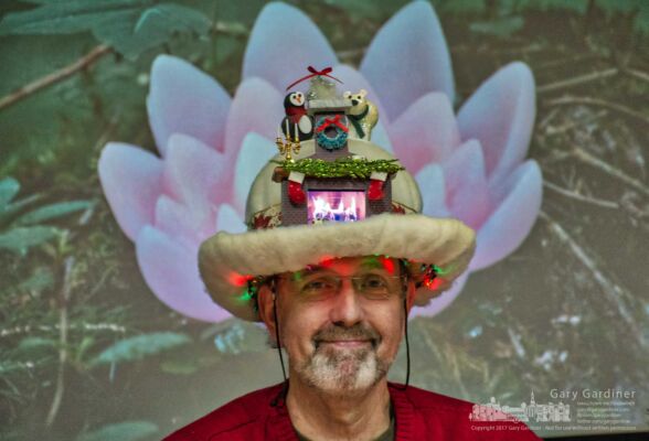 David Henry demonstrates the festive lights, artificial fireplace, and Christmas decorations attached to his furry hat before the start of the Arts Council of Westerville meeting. My Final Photo for Dec. 19, 2017. David Henry demonstrates the festive lights, artificial fireplace, and Christmas decorations attached to his furry hat before the start of the Arts Council of Westerville meeting. My Final Photo for Dec. 19, 2017.