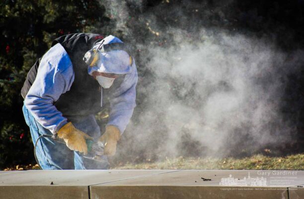 A worker cuts deep slots into the edges of limestone seats recently installed at the civic green in front of city hall to prevent skateboarders from using them for performing tricks. My Final Photo for Dec. 21, 2017. A worker cuts deep slots into the edges of limestone seats recently installed at the civic green in front of city hall to prevent skateboarders from using them for performing tricks. My Final Photo for Dec. 21, 2017.