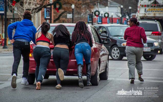 Four passengers push a disabled car through the State and College intersection in Uptown as a fifth runs along side. My Final Photo for Dec. 4, 2017. Four passengers push a disabled car through the State and College intersection in Uptown as a fifth runs along side. My Final Photo for Dec. 4, 2017.