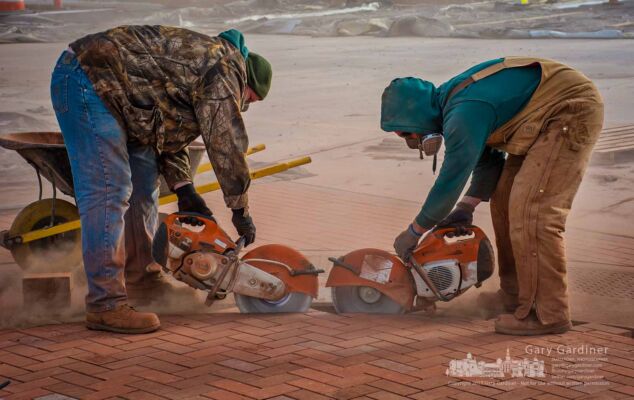 A pair of bricklayers cutting pavers reach the middle of an entrance built into the roadway across from the entrance to the Renaissance Hotel on Altair Parkway. My Final Photo for Dec. 14, 2017. A pair of bricklayers cutting pavers reach the middle of an entrance built into the roadway across from the entrance to the Renaissance Hotel on Altair Parkway. My Final Photo for Dec. 14, 2017.